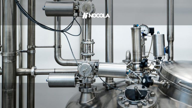 Close-up of stainless steel machinery and pipes in an industrial setting, showcasing modern engineering.