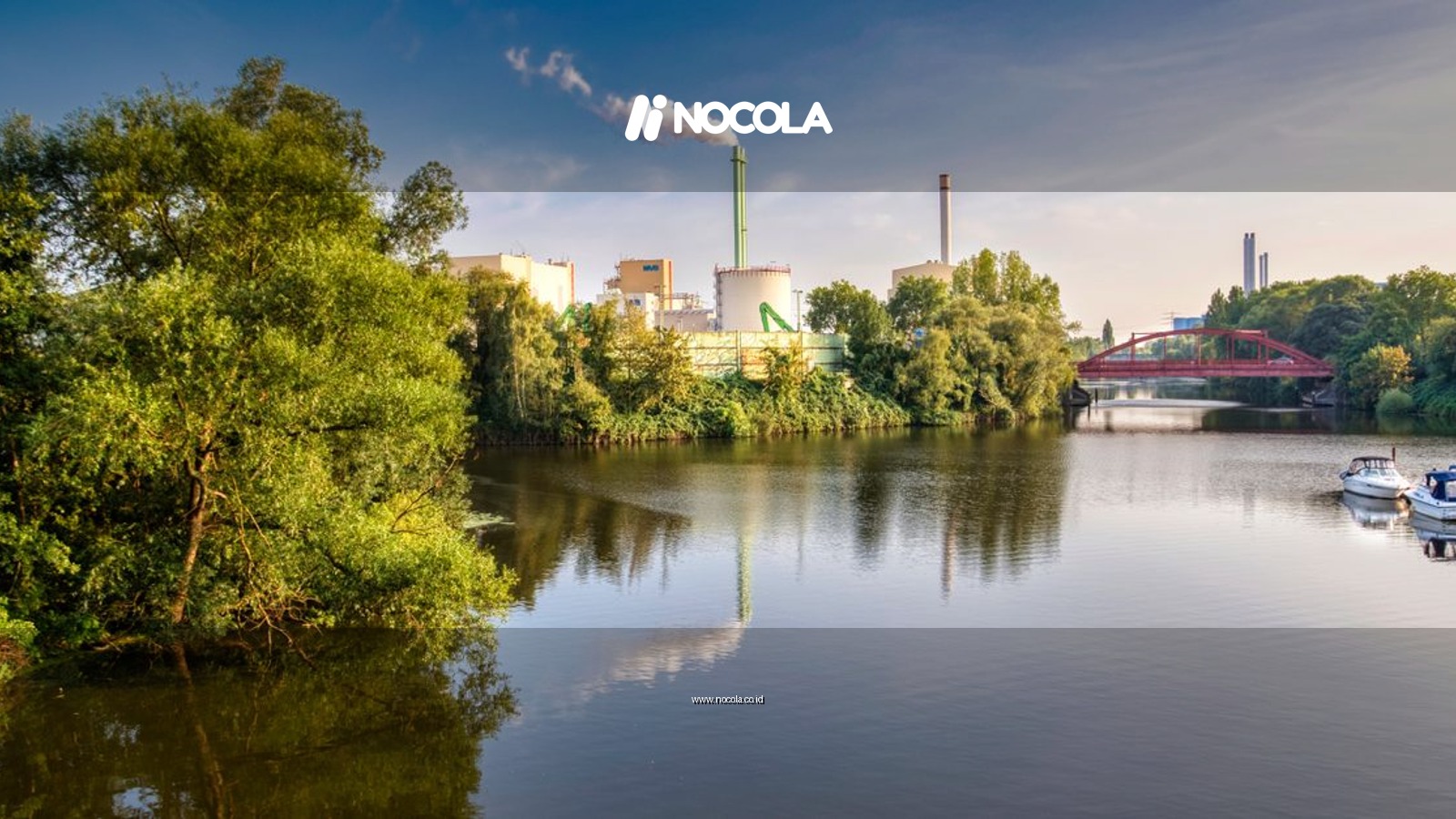 A scenic view of a river reflecting an industrial landscape with smoke stacks and blue sky in summer.