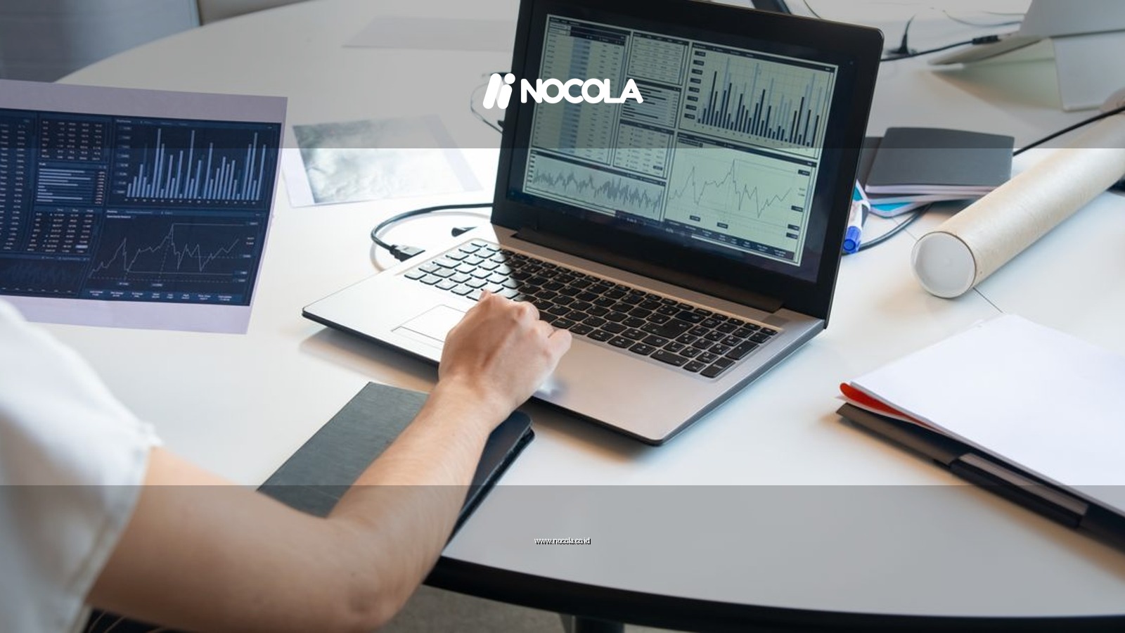 Business person evaluating financial charts on a laptop in a modern office setting.