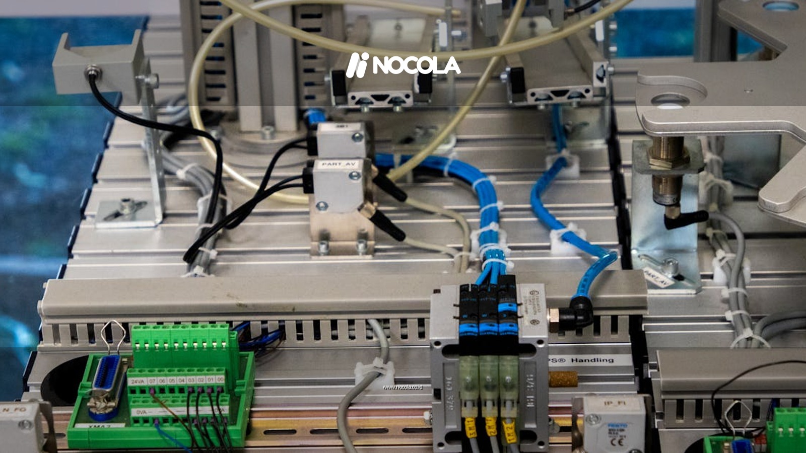 Close-up of industrial equipment showcasing electronic wiring and sensors in a manufacturing setup.